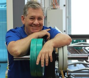 Natural testosterone support: Confident 55-year-old man in gym demonstrating energy, vitality, and healthy male hormones