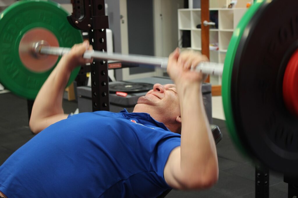 Man performing bench press to support healthy testosterone naturally