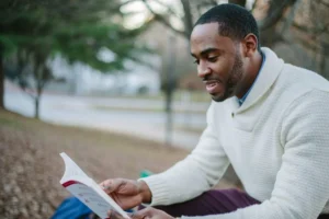 Men’s health recovery habit: man reading a book to support relaxation, balance, and sustainable daily energy