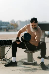 Nitric Oxide Boosters: Male athlete lifting dumbbells, showing how supplements support blood flow, recovery, and endurance 