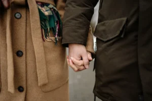 Man and woman holding hands outdoors, showing support and connection while promoting healthy lifestyle and communication 