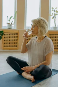 Woman over 40 drinking water after yoga to support energy, hormone balance, and natural menopause wellness 